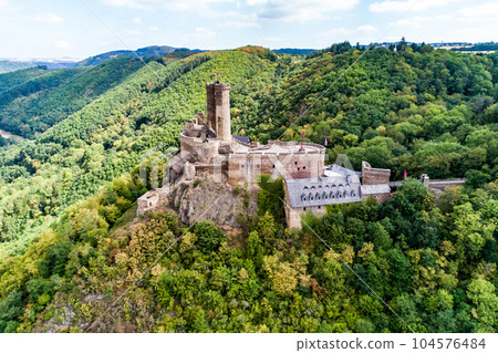 aerial view rock with medieval castle Ehrenburg on it near moselle river in Brodenbach with forest hills 104576484