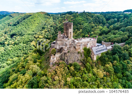 aerial view rock with medieval castle Ehrenburg on it near moselle river in Brodenbach with forest hills 104576485