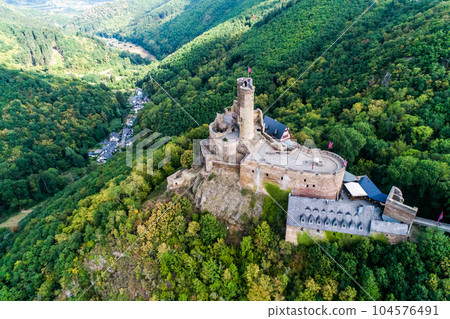 aerial view rock with medieval castle Ehrenburg on it near moselle river in Brodenbach with forest hills 104576491