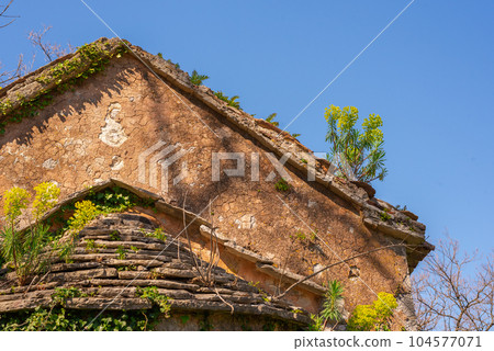 The old Church of St. Anne with a bell tower from the 14th century with flowers grown on the roof. Prcanj Montenegro 104577071