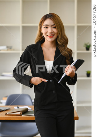 Portrait of female secretary, office manager or business assistant holding digital tablet standing in modern workplace Portrait of female secretary, office manager or business assistant holding digital tablet standing in modern workplace 104577266