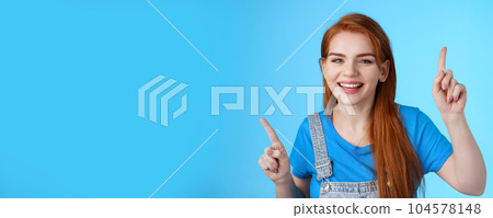 Close-up cheerful carefree redhead dancing girl pointing up, raising fingers, smiling amused, having fun, stand blue background entertained, enjoy music party, disco mood, carefree emotions concept Close-up cheerful carefree redhead dancing girl pointing up, raising fingers, smiling amused, having fun, stand blue background entertained, enjoy music party, disco mood, carefree emotions concept 104578148