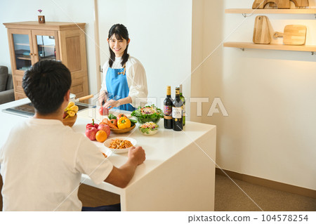 Men and women cooking at the counter kitchen Men and women cooking at the counter kitchen 104578254