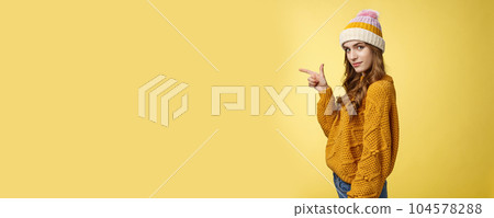 Profile shot confident flirty fashionable young 20s girl turning camera smiling pointing left inviting go together showing curious promotion cool place hang out, standing yellow background relaxed Profile shot confident flirty fashionable young 20s girl turning camera smiling pointing left inviting go together showing curious promotion cool place hang out, standing yellow background relaxed 104578288