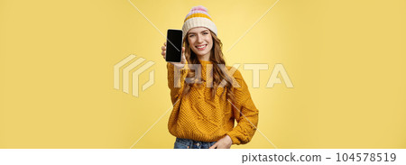 Charming outgoing smiling trendy girl extend arm showing you brand new smartphone, display grinning satisfied consulting friend what filter put using app edit photo mobile phone, yellow background Charming outgoing smiling trendy girl extend arm showing you brand new smartphone, display grinning satisfied consulting friend what filter put using app edit photo mobile phone, yellow background 104578519