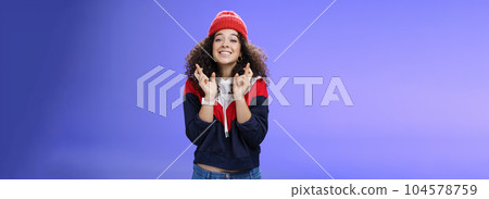 Dreamy optimistic woman praying friend will win standing supportive and excited smiling hopeful crossing fingers god good luck, waiting for miracle and dream come true posing against blue background 104578759