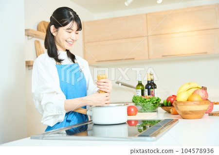 Woman cooking on island kitchen 104578936