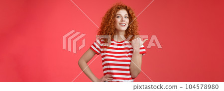 Accomplished good-looking redhead curly woman raise head proudly confident pointing thumb left smiling camera assertive sharing awesome product location recommend perfect store offer 104578980