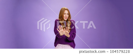 Gross take it away. Portrait of disgusted redhead woman step back and waving palms over body in refusal and no gesture grimacing and squinting from bad smell or aversion over purple wall Gross take it away. Portrait of disgusted redhead woman step back and waving palms over body in refusal and no gesture grimacing and squinting from bad smell or aversion over purple wall 104579228