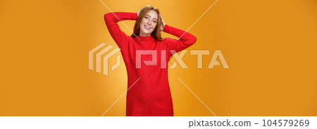 Romantic and sensual cute ginger girlfriend in elegant warm red winter dress holding hands behind head relaxed and carefree smiling delighted tilting head enjoying leisure and holidays Romantic and sensual cute ginger girlfriend in elegant warm red winter dress holding hands behind head relaxed and carefree smiling delighted tilting head enjoying leisure and holidays 104579269