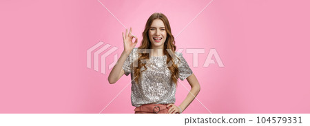 Okay got it. Charming friendly-looking outgoing glamour young attractive woman show ok no problem gesture smiling assured confident everything perfect, recommend excellent service, pink background 104579331