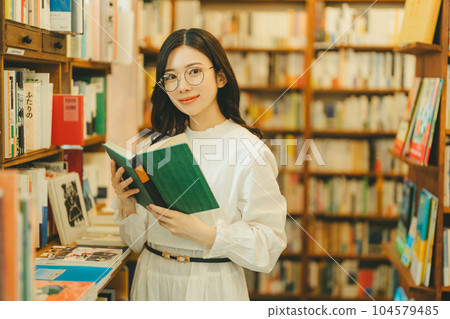 young woman in a bookstore young woman in a bookstore 104579485