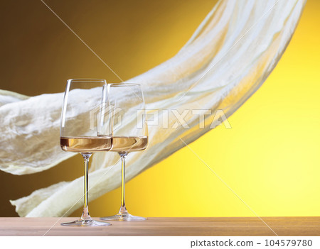 Glasses of white wine on a yellow background. Glasses of white wine on a yellow background. 104579780