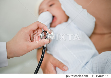Close up view of adorable baby being checked by a doctor using a stethoscope. 104580453