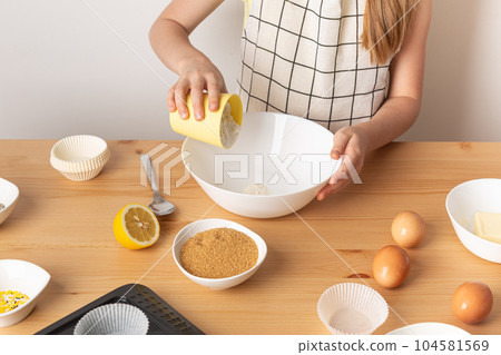 Girl is cooking muffins in the kitchen process concept ingredients simple 104581569