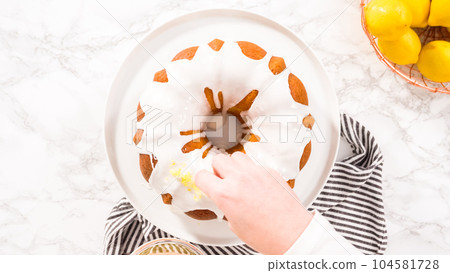 Flat lay. Step by step. Garnishing lemon bundt cake with lemon zest on top of the white glaze. Flat lay. Step by step. Garnishing lemon bundt cake with lemon zest on top of the white glaze. 104581728