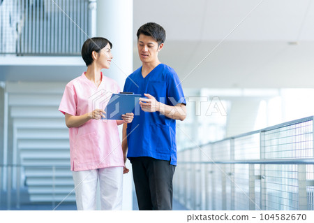 A doctor and a nurse having a meeting at a hospital 104582670