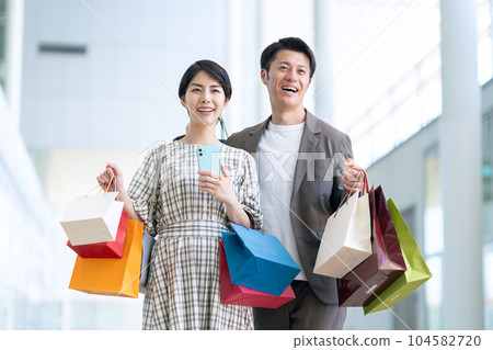 一對年輕夫婦在購物時操作智能手機 104582720