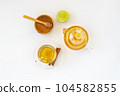 Top view of a cup of tea with ginger root, lime, cinnamon and teapot on white background. Health drink concept.. 104582855