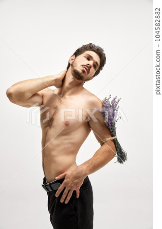 Portrait of handsome young dark-haired man posing isolated over studio background. Male natural beauty concept. Portrait of handsome young dark-haired man posing isolated over studio background. Male natural beauty concept. 104582882