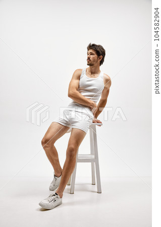 Portrait of handsome young dark-haired man posing isolated over studio background. Male natural beauty concept. 104582904