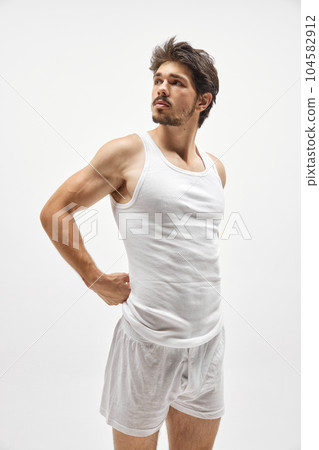 Muscular male fashion model wearing cotton underwear posing isolated over white background. Concept of men's health, beauty, fitness, fashion. 104582912