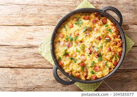 Dibbelabbes German casserole is a traditional country oven dish with potatoes, leeks, onions and bacon close-up in a pan. Horizontal top view Dibbelabbes German casserole is a traditional country oven dish with potatoes, leeks, onions and bacon close-up in a pan. Horizontal top view 104585077