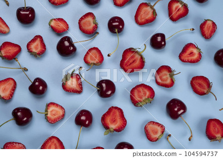 background of ripe strawberries and cherries on a blue background. Trendy,fruity,summer loop background background of ripe strawberries and cherries on a blue background. Trendy,fruity,summer loop background 104594737