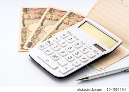 計算器、存摺、金錢和圓珠筆 計算器、存摺、金錢和圓珠筆 104596364