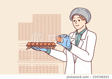Woman factory worker holds chicken eggs while checking finished product for quality 104596891