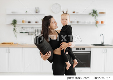 Mother and daughter preparing for yoga with mat at home Mother and daughter preparing for yoga with mat at home 104596946