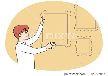 Man hanging frames on wall Man hanging frames on wall 104597054