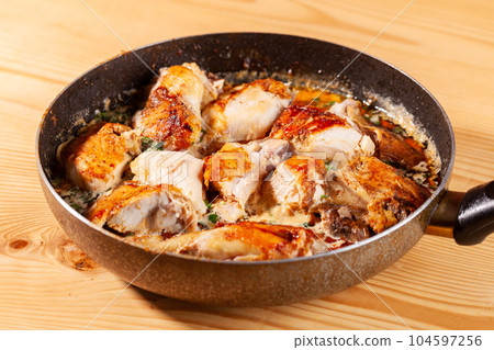 Shkmeruli, chicken in garlic sauce on a frying pan Shkmeruli, chicken in garlic sauce on a frying pan 104597256