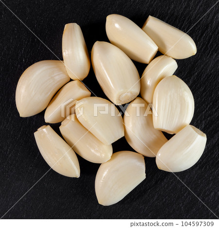 Garlic cloves. Raw garlic isolated on black background. Vegetable Garlic cloves. Raw garlic isolated on black background. Vegetable 104597309