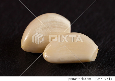 Garlic cloves. Raw garlic isolated on black background. Vegetable 104597314