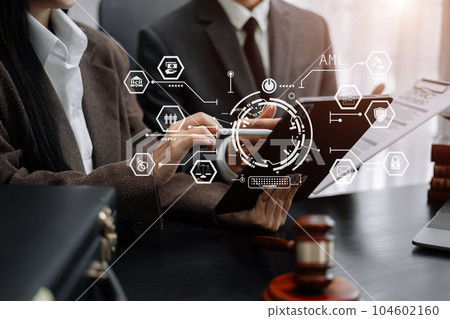 Judge in a courtroom using laptop and tablet with AML anti money laundering icon on virtual screen. Judge in a courtroom using laptop and tablet with AML anti money laundering icon on virtual screen. 104602160