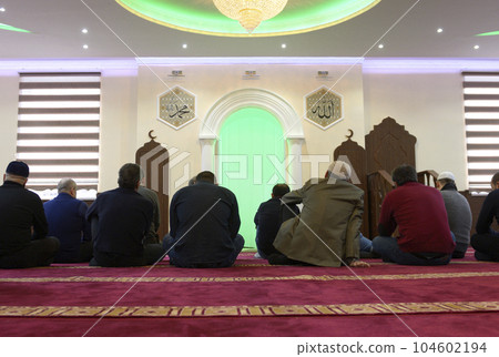 Group of Muslim men sitting on a floor of a mosgue waiting for mullah Group of Muslim men sitting on a floor of a mosgue waiting for mullah 104602194