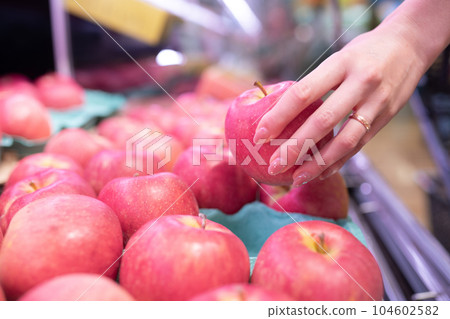 Woman's hand picking an apple Woman's hand picking an apple 104602582