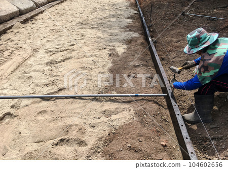 Builder is using cement molds to be anchored with steel for strength in pouring the cement slab 104602656