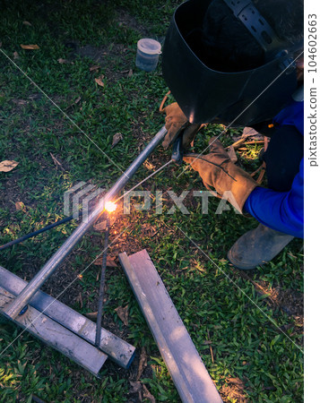 Man welding steel, blurred on black background Man welding steel, blurred on black background 104602663