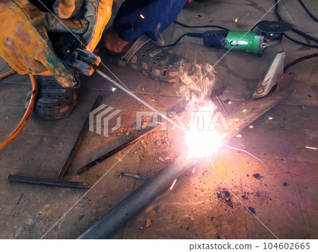 Man welding steel, blurred on black background Man welding steel, blurred on black background 104602665