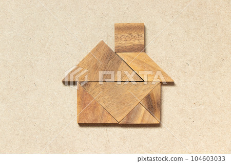 Wooden tangram puzzle in home shape for dream home or happy life concept Wooden tangram puzzle in home shape for dream home or happy life concept 104603033