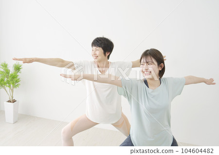 女兒和母親在家做瑜伽英雄姿勢 104604482