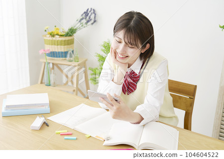 一邊學習一邊看智能手機休息的女高中生 104604522