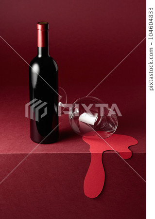 Bottle and glass of red wine on a red background. 104604833
