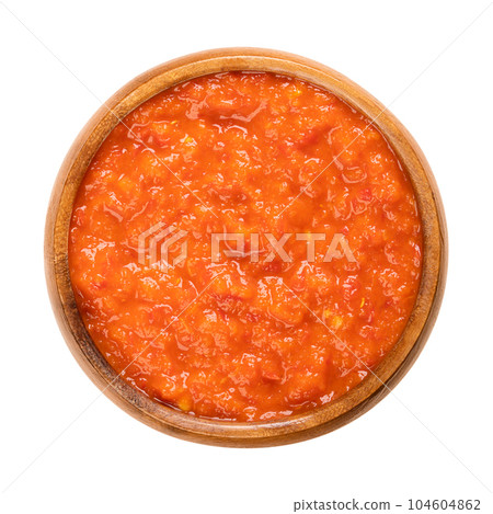 Ajvar, relish made of roasted sweet bell peppers, in a wooden bowl. Condiment, bread spread and side dish, popular in the Balkans. Depending on capsaicin content sweet (traditional), piquant, or hot. 104604862