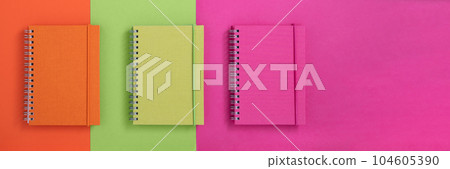 Banner with colorful notebooks on orange, green and pink background. Banner with colorful notebooks on orange, green and pink background. 104605390
