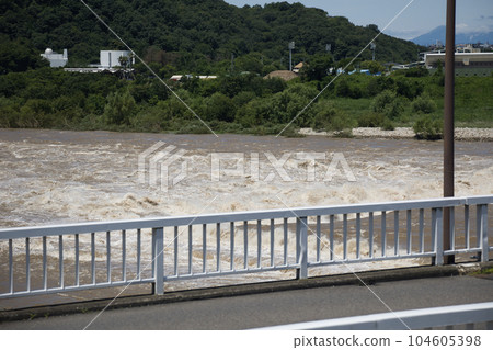 A muddy river with a brown and swollen water after the rain 104605398
