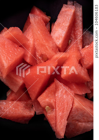 Red fresh watermelon slices, triangular fresh fruit snack on black backround, vertical summer textured image. 104606183