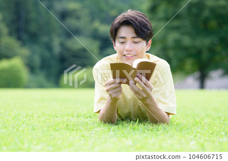 一個人躺在草坪上看書 一個人躺在草坪上看書 104606715